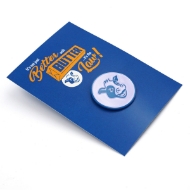 The blue and white cow head pin is situated on a blue placard that says in yellow and white text "It's not just better with butter...it's the law."