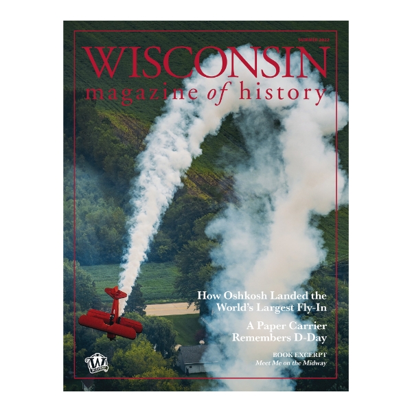 Cover of the Wisconsin Magazine of History Summer 2022 edition. An aerial photo of a red biplane as it takes a sharp corner, leaving curved trail of white smoke. Green fields in the background.