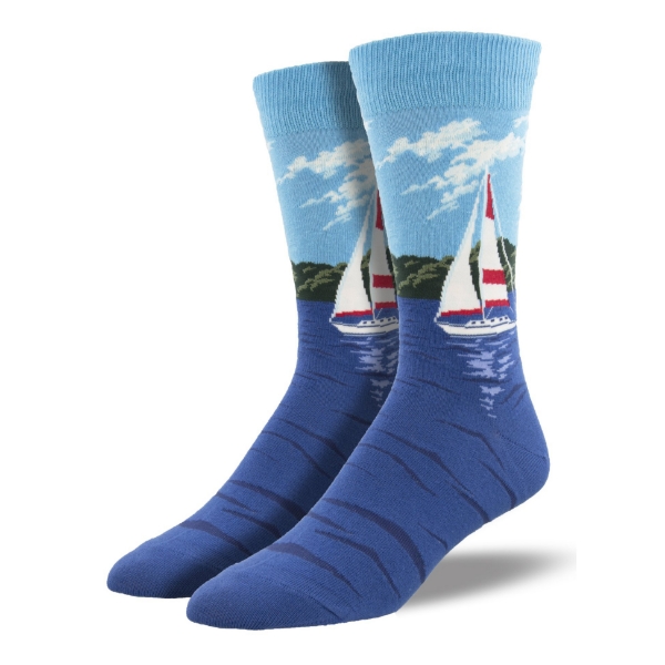 Two socks with illustration of red and white sail boat on blue water. Background of green trees and light blue sky. 