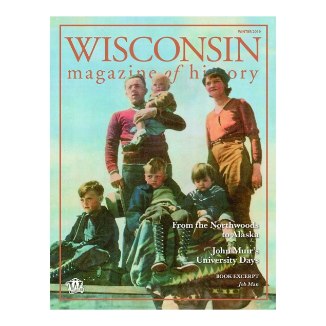 Full page color photo dated 1935 of father and mother with four children as they prepare to settle in Alaska. 