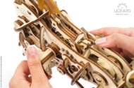 Close-up of mechanical wooden horse model by Ugears shown from above, showing the horse's back. Made from small, laser-cut pieces of thin plywood.