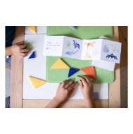 Overhead view Tangram block mini set showing childrens hands playing with the felt blocks.