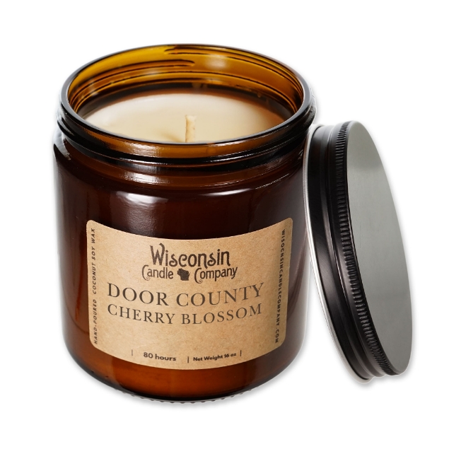 Door County Cherry Blossom Candle - a white wax candle in brown jar with black tin lid.